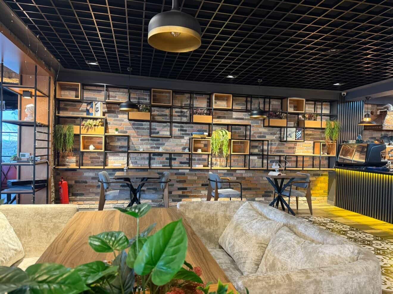 Pruva Lounge iç mekan - tuğla duvar ve modern raf tasarımı
